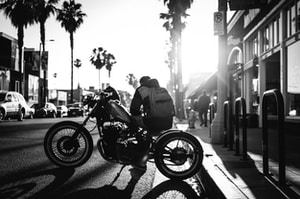 man sitting on cruiser motorcycle on grayscale photograyphy